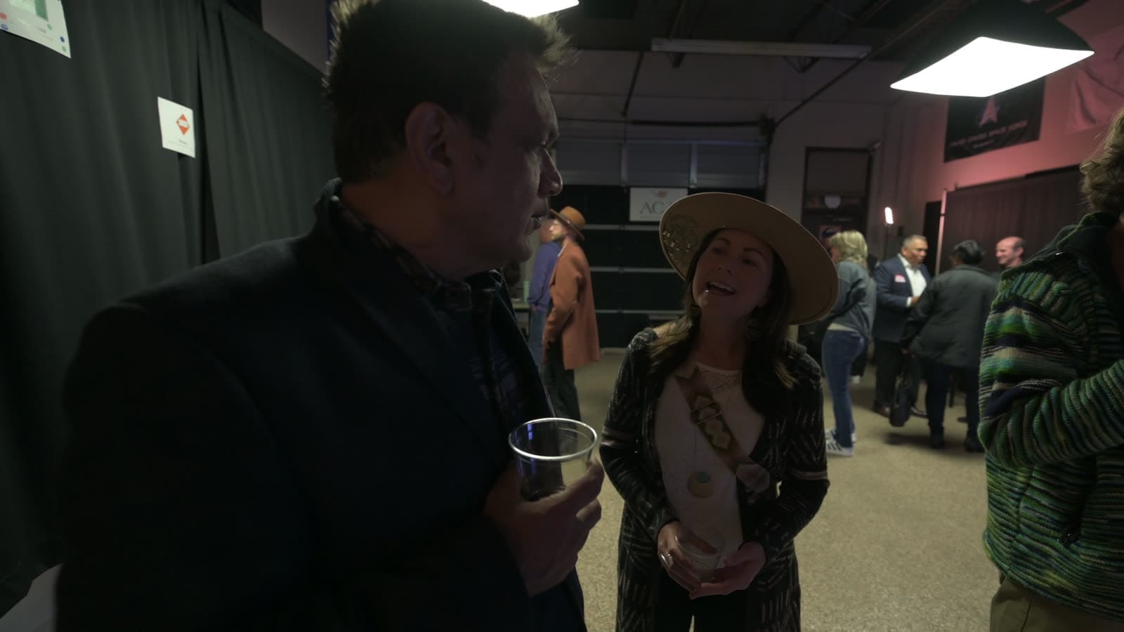 Attendees laughing mid-conversation, drinks in hand