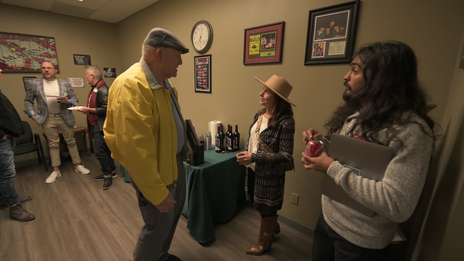 Three guests chatting by the drinks table