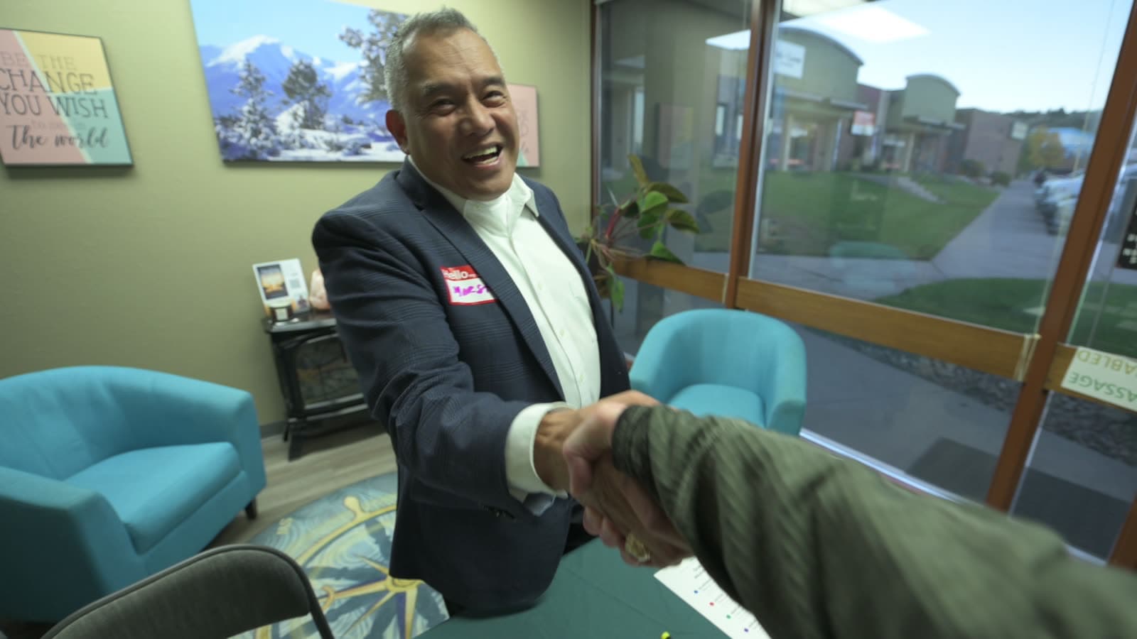 A host welcomes a guest with a handshake at check-in